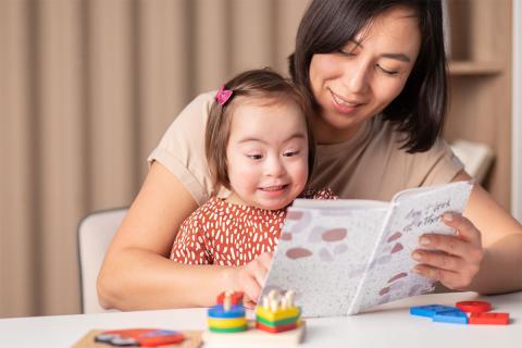 Caregiver with small child reading a book